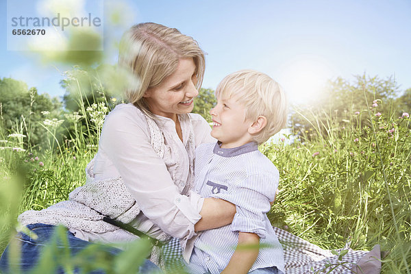 Deutschland  Köln  Mutter und Sohn beim Picknick auf der Decke sitzend