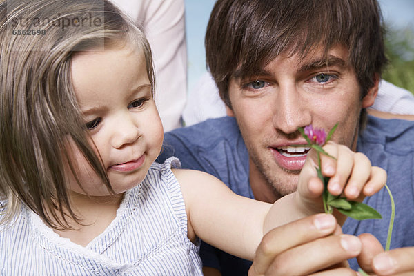 Girl holding flower with parents  close up