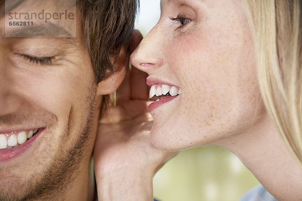 Young woman whispering to man  close up