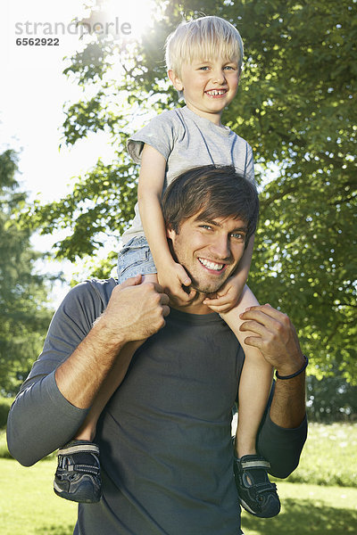 Germany  Cologne  Father carrying son on shoulders  smiling  portrait