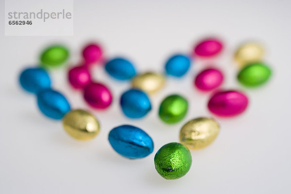 Colourful foil wrapped chocolates on white background