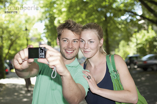 Germany  North Rhine Westphalia  Duesseldorf  Couple taking photo of themselves  smiling