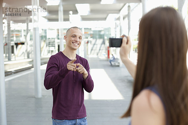 Young woman taking photograph of man
