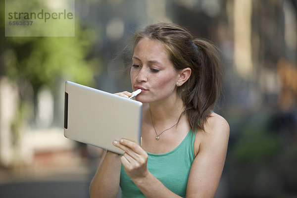 Germany  North Rhine Westphalia  Cologne  Young woman using digital tablet as mirror mouth