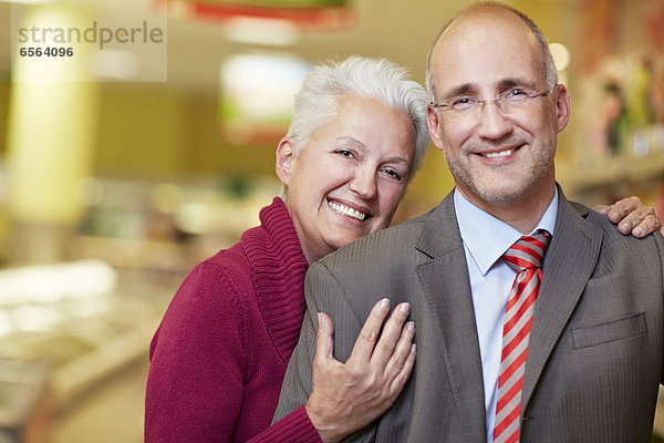 Deutschland  Köln  Ehepaar im Supermarkt  lächelnd  Portrait