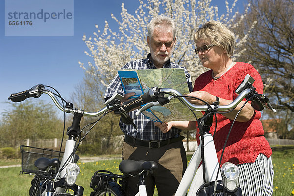 Germany  Bavaria  Senior couple watching road map