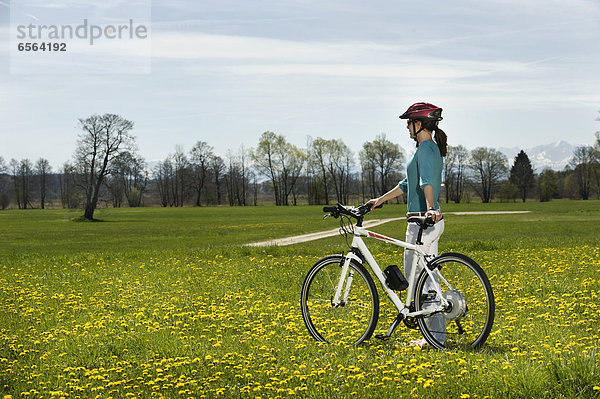 Mid adult woman riding electric bicycle