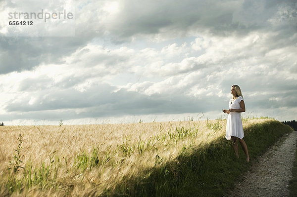 Mature woman standing in grain field