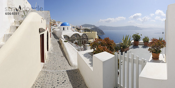 Griechenland  Blick auf das Dorf Oia mit Kopfsteinpflasterweg und Tor bei Santorini