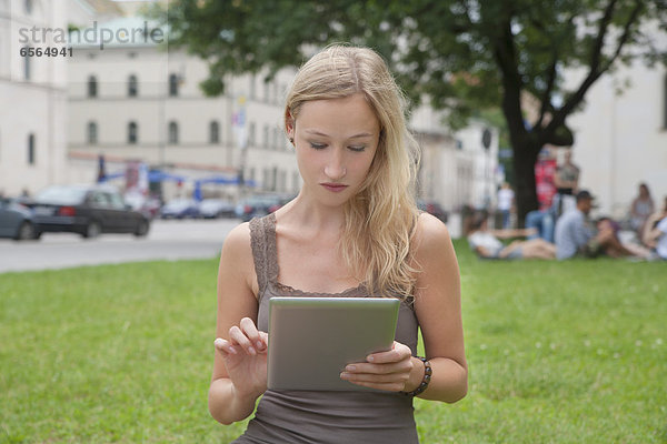 Junge Frau mit Tablet PC vor der Ludwig-Maximilians-Universität