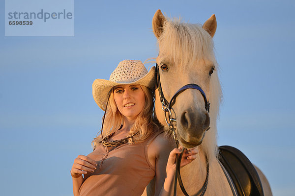 Lächelnde Frau mit Pferd unter blauem Himmel  Portrait