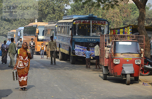 Straßenszene mit indischen Pilgerbussen  Lastentuktuk und Passanten vor Ruinen der alten Universität von Nalanda  Ragir  Bihar  Indien  Asien