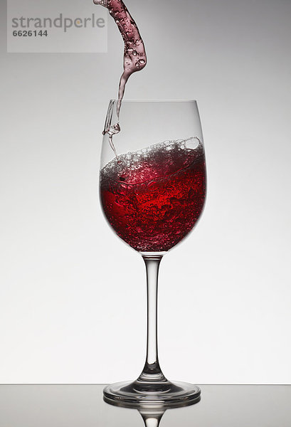 Glas Wein füllen füllt füllend Rotwein