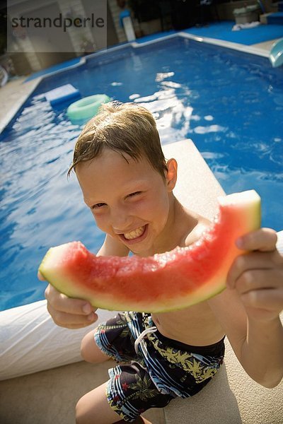 Junge - Person Beckenrand Wassermelone essen essend isst