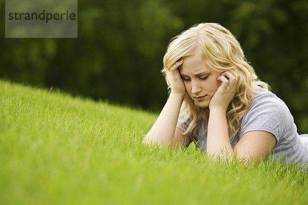 Junge Frau auf Gras liegend
