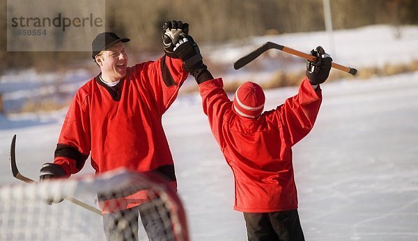 Menschlicher Vater Sohn Hockey spielen