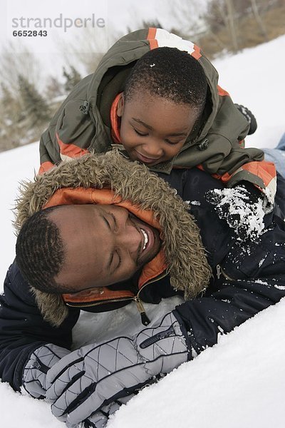 Menschlicher Vater  Sohn  spielen  Schnee