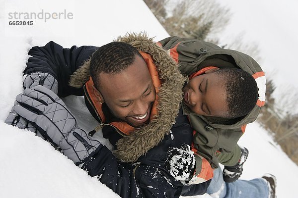 Menschlicher Vater  Sohn  spielen  Schnee