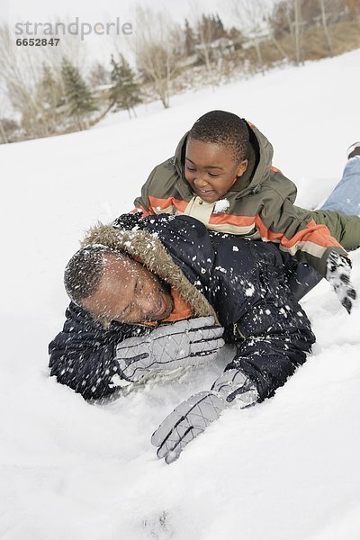 Menschlicher Vater  Sohn  spielen  Schnee