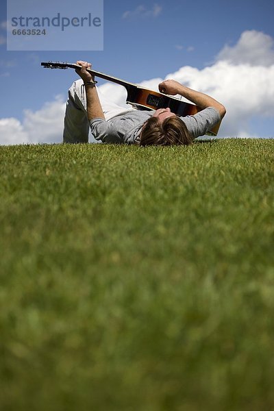 Mann  Gitarre  Gras  spielen