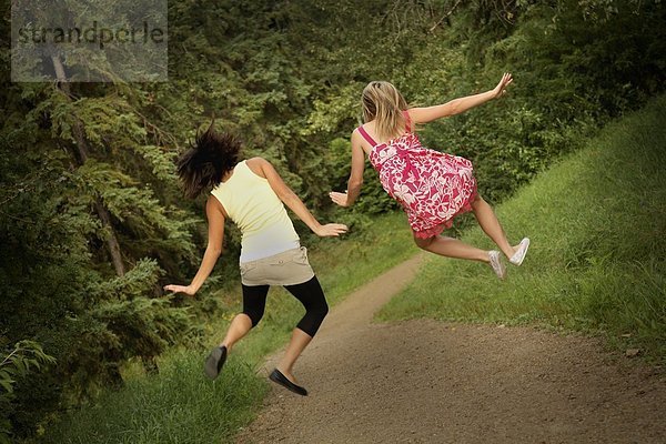Jugendlicher  springen  2  Mädchen