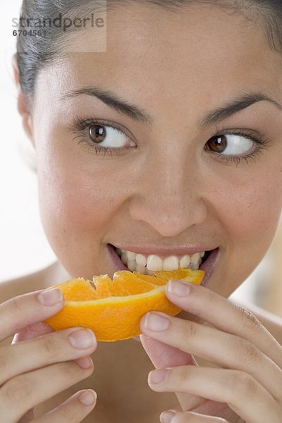 Frau isst orange