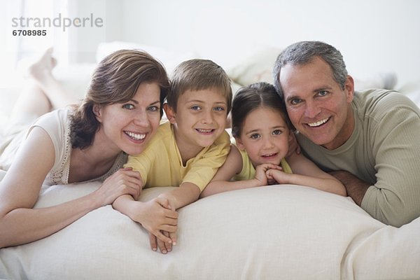 Familie auf Bett liegend