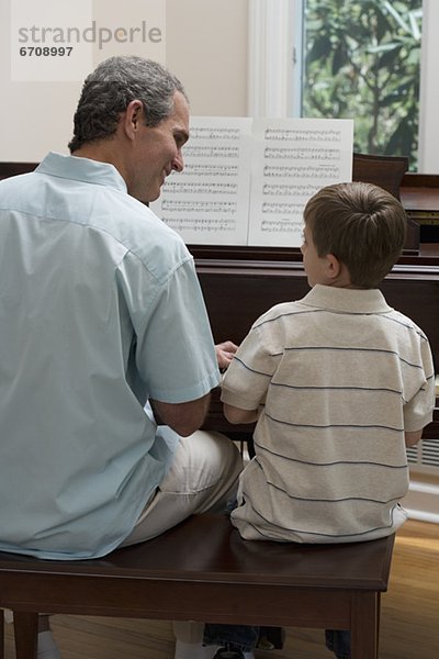 Menschlicher Vater  Sohn  Klavier  jung  spielen