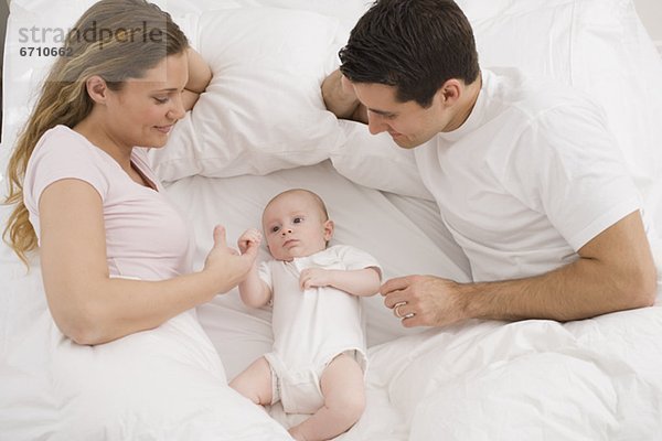 lächeln  Menschliche Eltern  Bett  Baby