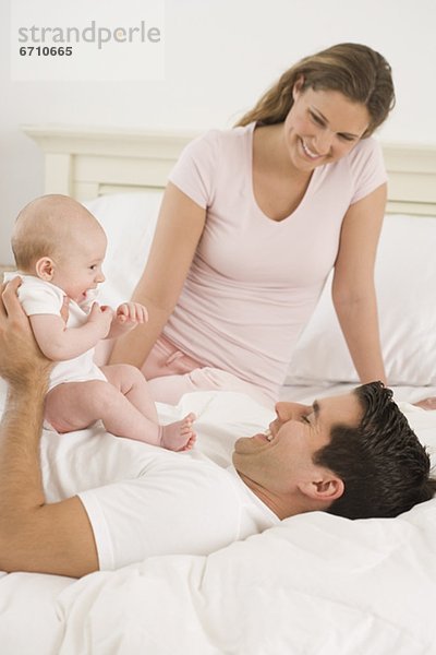 Menschliche Eltern  Bett  Baby  spielen