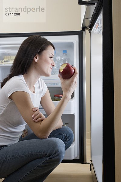 Frau  offen  frontal  Kühlschrank  Apfel  essen  essend  isst