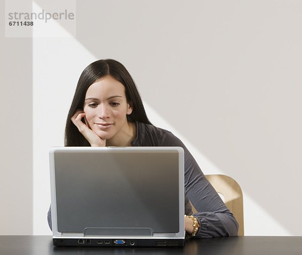 Frau blickt auf laptop