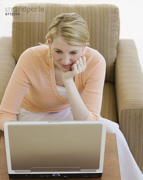 Frau blickt auf laptop