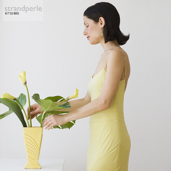 Frau Anordnen von Blumen in der vase