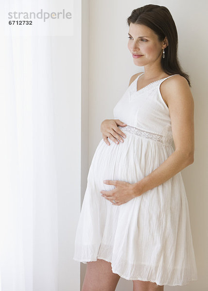 Schwangere Frau mit Händen auf Bauch