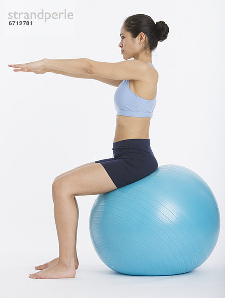 Frau sitzt auf gymnastikball