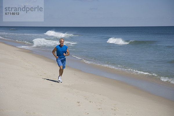 älterer Mann joggen am Strand