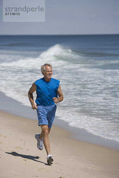 älterer Mann joggen am Strand