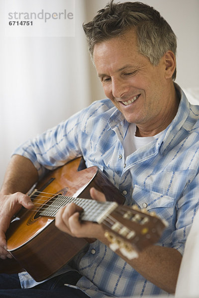 Mann spielt Akustikgitarre