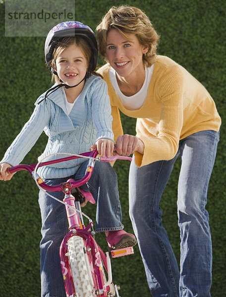 Großmutter  Mutter und Tochter mit Fahrrad in herbstlicher Umgebung