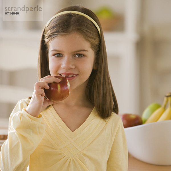 Mädchen beißt in einen Apfel
