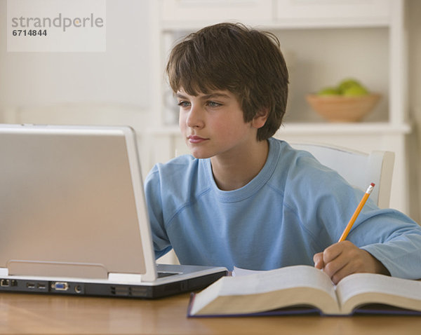 Boy Hausaufgaben mit laptop