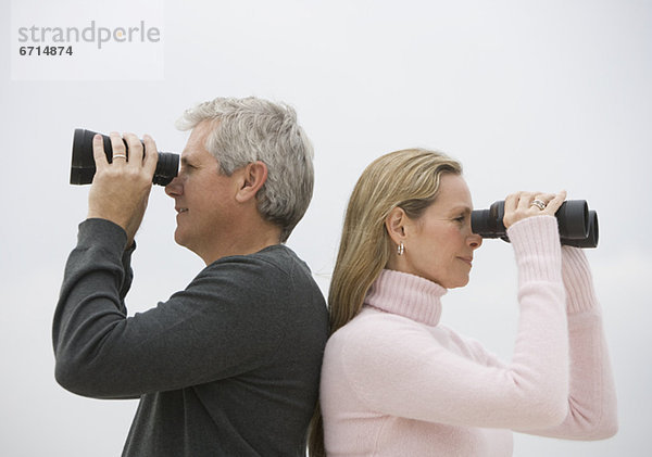 Paar looking through binoculars