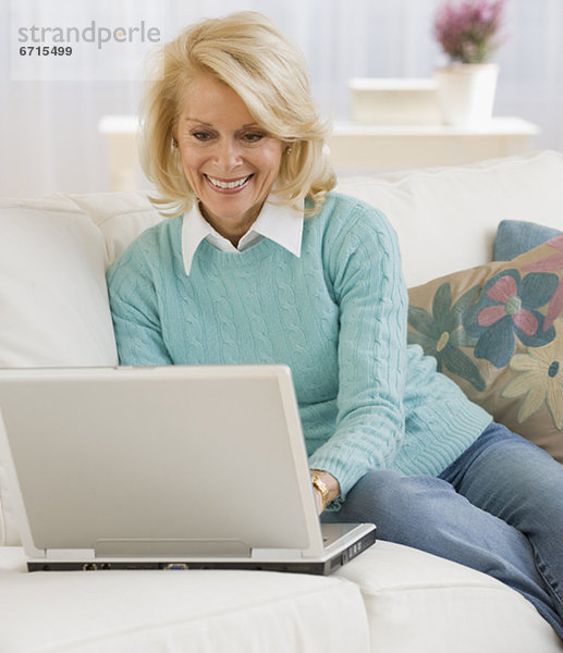 Seniorin schaut auf ihren Laptop