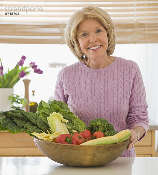 Senior Senioren Frau Gemüse halten
