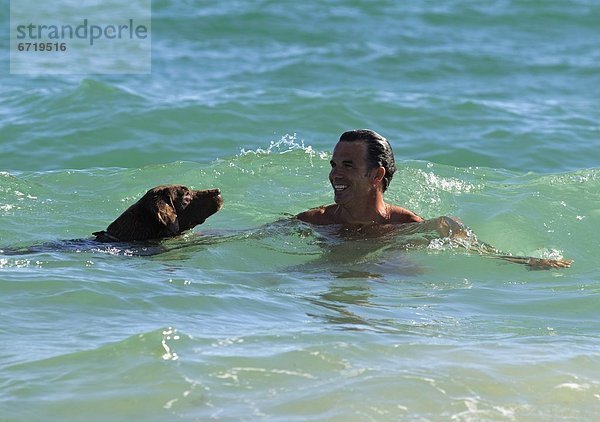 Mann Ozean Hund schwimmen
