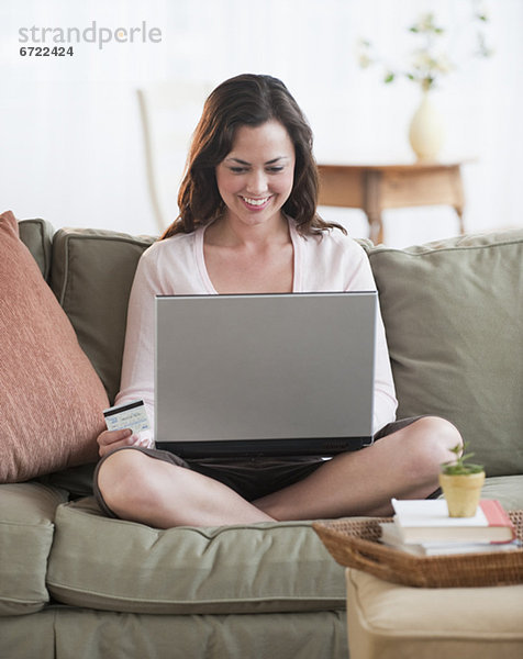 Frau benutzt Laptop im Wohnzimmer