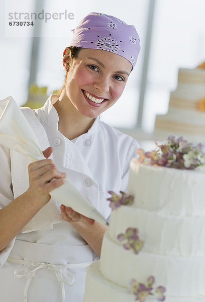 junge Frau junge Frauen Portrait Fröhlichkeit Hochzeit Kuchen schmücken