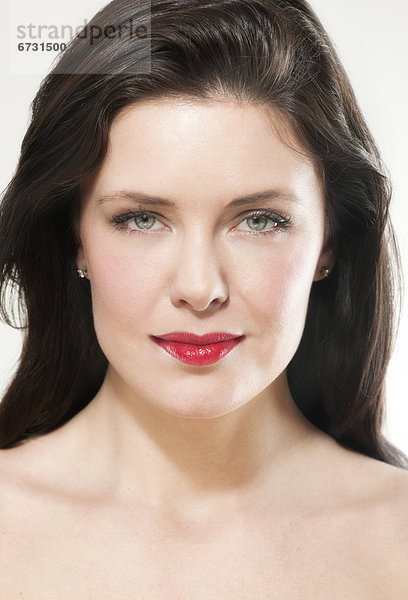 Portrait einer jungen Frau mit rot geschminkten Lippen