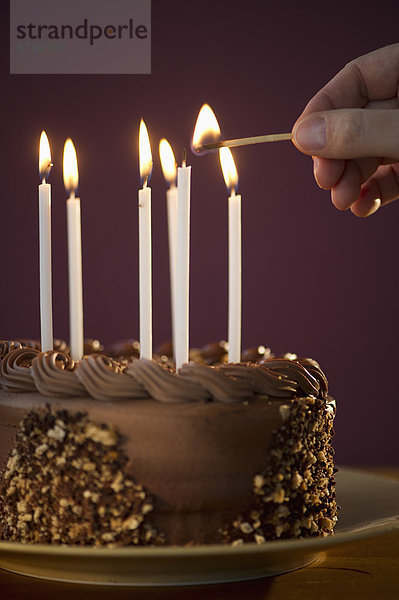 anzünden Mann Geburtstag Kuchen Kerze Schokolade schießen Studioaufnahme